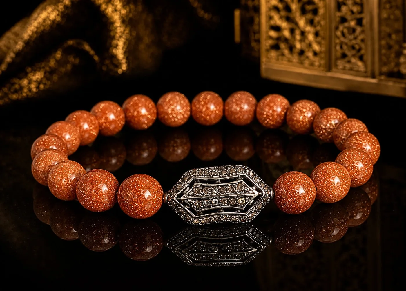 Ru Antique Jewellery hero image: a goldstone bead bracelet with an ornate silver centre piece on black glass