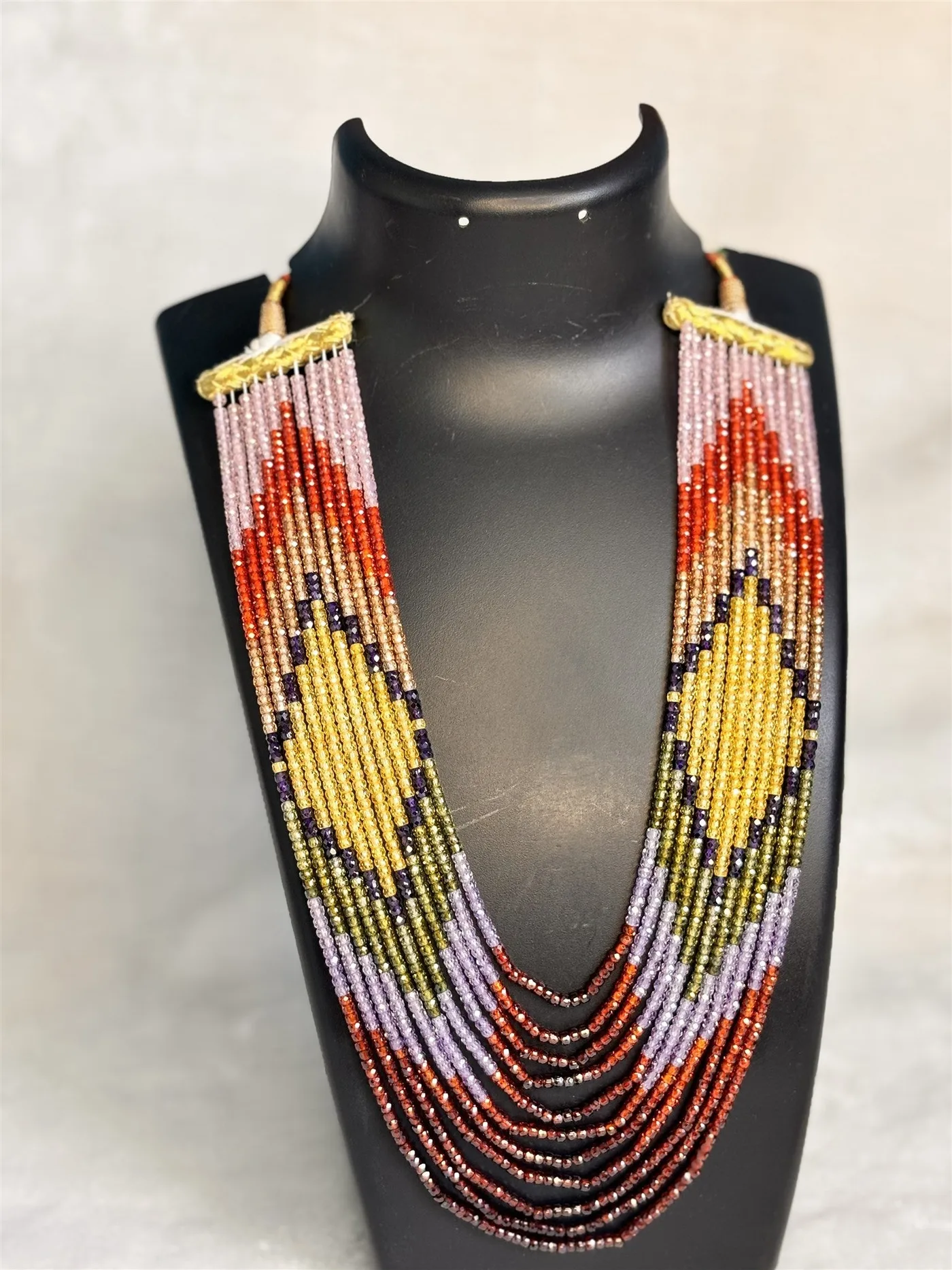 Multi-stone beaded necklace on a black bust