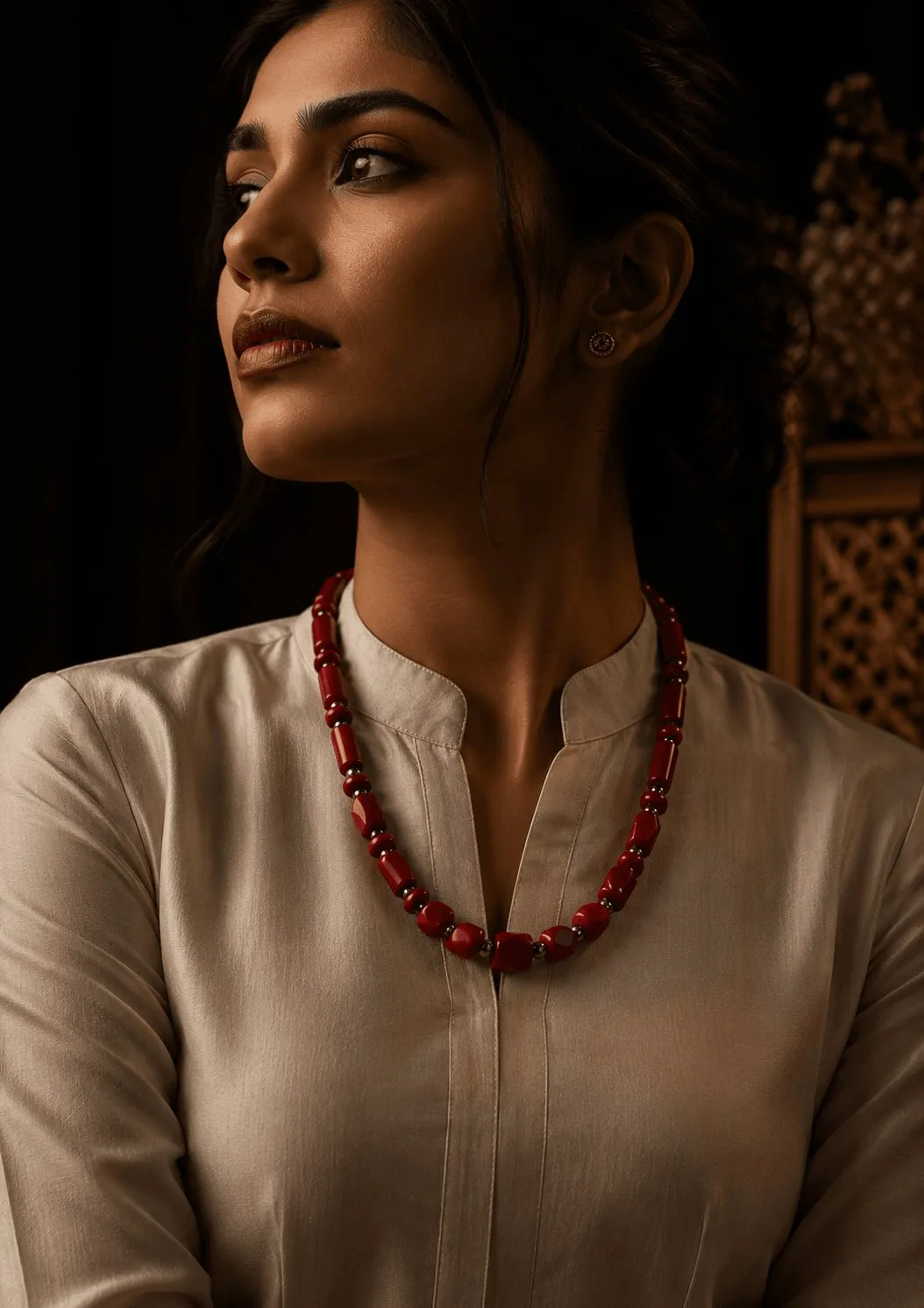 Model wearing layered gemstone necklaces
